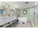 Large bathroom with double vanities, modern tub, walk-in shower, decorative mirrors and tile floors at 2701 W Bay Ave, Tampa, FL 33611