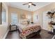 Inviting bedroom with a colorful quilt, wood floors, a ceiling fan, and a window to let in light at 2701 W Bay Ave, Tampa, FL 33611