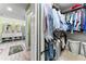 Walk-in closet full of hanging clothes, with a view of the primary bathroom at 2701 W Bay Ave, Tampa, FL 33611