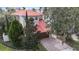 Charming two-story home with a red tile roof, lush greenery, and a paver driveway leading to a two-car garage at 2701 W Bay Ave, Tampa, FL 33611
