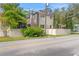 Exterior view of home featuring lush landscaping, complemented by the red tile roof and screened in porch at 2701 W Bay Ave, Tampa, FL 33611