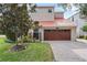 Home with a two-car garage, red tile roof, and brick paved driveway at 2701 W Bay Ave, Tampa, FL 33611