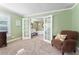 Sitting room featuring green walls, carpet, and a chair with a view of an ensuite bathroom at 2701 W Bay Ave, Tampa, FL 33611