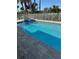 Sparkling blue pool with integrated hot tub, surrounded by tropical landscaping and a privacy fence at 320 Capstan Dr, Placida, FL 33946