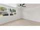 Sunlit bedroom with large windows, ceiling fan, and stylish floors at 3544 Edenwood Dr, Holiday, FL 34691
