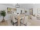 Stylish dining room with a light wood table, modern light fixture and view to the next room at 3544 Edenwood Dr, Holiday, FL 34691