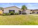 Charming single-story home featuring a palm tree, attached garage, and beautifully landscaped front yard at 3544 Edenwood Dr, Holiday, FL 34691
