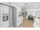 Open-concept kitchen with stainless steel appliances, white cabinets, and light wood floors at 3544 Edenwood Dr, Holiday, FL 34691