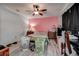 Bedroom featuring pink accent wall, ceiling fan, wood floors, and desk at 3728 Parkway Blvd, Land O Lakes, FL 34639