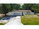 Well-kept single-story home with an attached garage, surrounded by mature trees and a fenced in yard at 3728 Parkway Blvd, Land O Lakes, FL 34639
