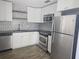 Updated kitchen featuring stainless steel appliances, white cabinets, and modern backsplash at 4043 La Pasida Ln, New Port Richey, FL 34655