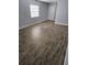 Bright living room with wood-style flooring, window, and neutral paint at 4043 La Pasida Ln, New Port Richey, FL 34655