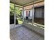 Tiled and screened porch gives views of exterior, including AC unit, window, and plants at 4043 La Pasida Ln, New Port Richey, FL 34655