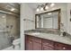 Well-lit bathroom vanity with decorative mirror, granite countertop, step-in shower with seating at 4175 Northmeadow Cir # 4175, Tampa, FL 33618