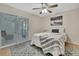 Bedroom with a large window leading to a lanai and featuring a ceiling fan and large decorative rug at 4175 Northmeadow Cir # 4175, Tampa, FL 33618