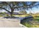 Beautiful view of grounds with wooden walkway and mature trees; community building in the background at 4175 Northmeadow Cir # 4175, Tampa, FL 33618