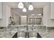 Modern kitchen with granite countertops, stainless steel sink, and view of living area with lots of natural light at 4175 Northmeadow Cir # 4175, Tampa, FL 33618