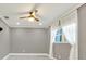 Bright bedroom featuring a ceiling fan, light gray paint, window, and wood-look flooring at 4310 S Coolidge Ave, Tampa, FL 33611
