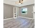 Serene bedroom featuring gray walls, laminate floors, a modern white shelving unit, and a bright window at 4310 S Coolidge Ave, Tampa, FL 33611
