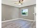 Cozy bedroom featuring gray walls, laminate floors, a modern white shelving unit, and a bright window at 4310 S Coolidge Ave, Tampa, FL 33611