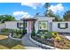 Charming home featuring a well-manicured front yard with a decorative rock border and beautiful pink front door at 4310 S Coolidge Ave, Tampa, FL 33611