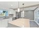 Modern kitchen with stainless steel appliances, white cabinetry, and a spacious island with quartz countertops at 4310 S Coolidge Ave, Tampa, FL 33611