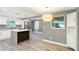 Open-concept kitchen features a center island, stainless steel refrigerator, and modern lighting at 4310 S Coolidge Ave, Tampa, FL 33611