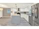 Bright kitchen with stainless steel appliances, white cabinetry, a gray backsplash, and a spacious island at 4310 S Coolidge Ave, Tampa, FL 33611