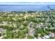 Stunning aerial view of a lush residential neighborhood near a bay, with mature trees and well-maintained homes at 511 San Jose Dr, Dunedin, FL 34698