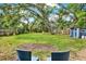 A lush backyard with a storage shed, mature trees, and a fire pit area perfect for outdoor entertaining at 511 San Jose Dr, Dunedin, FL 34698