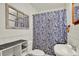 Bathroom featuring tile floors, shower/tub, floral shower curtain, vanity, and a wall mirror at 511 San Jose Dr, Dunedin, FL 34698