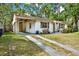 Charming single-story home featuring a covered carport, decorative shutters, and well-maintained front yard at 511 San Jose Dr, Dunedin, FL 34698
