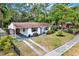 A beautifully landscaped front yard leading to a well-maintained home with a covered carport at 511 San Jose Dr, Dunedin, FL 34698