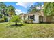 A well-maintained front yard featuring green grass, a palm tree, and a home with charming curb appeal at 511 San Jose Dr, Dunedin, FL 34698