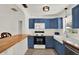 Charming kitchen with blue cabinets, a farmhouse sink, stainless steel appliances, and butcher block countertops at 511 San Jose Dr, Dunedin, FL 34698