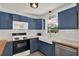 Charming kitchen with blue cabinets, white tile backsplash, and a farmhouse sink under a bright window at 511 San Jose Dr, Dunedin, FL 34698