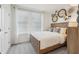 Bedroom with wood bed frame, neutral linens, natural light, and decorative wall art at 5133 Harbinger Rd, Spring Hill, FL 34608