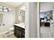 Clean bathroom with dark vanity and fixtures, adjacent to a brightly lit office space at 5150 Bay Isle Cir, Clearwater, FL 33760
