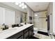 Modern bathroom features a double sink vanity with a white countertop and a glass-enclosed shower with tiled walls at 5150 Bay Isle Cir, Clearwater, FL 33760
