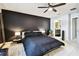 Bedroom features a large bed, dark accent wall, ceiling fan, and ensuite bathroom at 5150 Bay Isle Cir, Clearwater, FL 33760