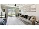 Bright living room featuring an exit to the backyard, a ceiling fan, and luxury vinyl plank flooring at 5150 Bay Isle Cir, Clearwater, FL 33760