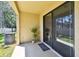 Covered patio includes a sliding glass door, a potted plant, an AC unit, green grass and privacy fence at 5150 Bay Isle Cir, Clearwater, FL 33760