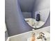 Stylish powder room with white wainscoting, pedestal sink, round mirror, and blue-gray paint at 5150 Bay Isle Cir, Clearwater, FL 33760