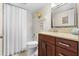 Bathroom featuring a dark wood vanity with granite countertops, and a shower with white tiled walls at 5600 Bay Pines Lakes Blvd, St Petersburg, FL 33708