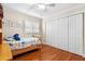 Comfortable bedroom featuring wood floors, bright windows, and closet space for storage at 5600 Bay Pines Lakes Blvd, St Petersburg, FL 33708