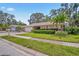 Well-manicured front yard and exterior of home featuring a charming single-story design and lush landscaping at 5600 Bay Pines Lakes Blvd, St Petersburg, FL 33708