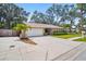 Attractive home featuring a lush lawn, mature trees, and well-maintained landscaping at 5600 Bay Pines Lakes Blvd, St Petersburg, FL 33708