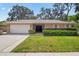 Charming single-story home with a lush green lawn, well-maintained landscaping, and a two-car garage at 5600 Bay Pines Lakes Blvd, St Petersburg, FL 33708