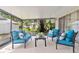 Enclosed patio with comfortable blue seating and views of the landscaped backyard at 5600 Bay Pines Lakes Blvd, St Petersburg, FL 33708