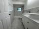 Bright bathroom featuring a bathtub with white tiles and a double sink vanity, providing a clean, modern, and functional space at 5911 63Rd N Ter, Pinellas Park, FL 33781